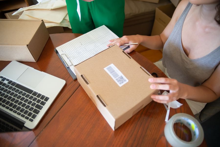 Bestellingen verwerken achter een laptop, met dozen op tafel