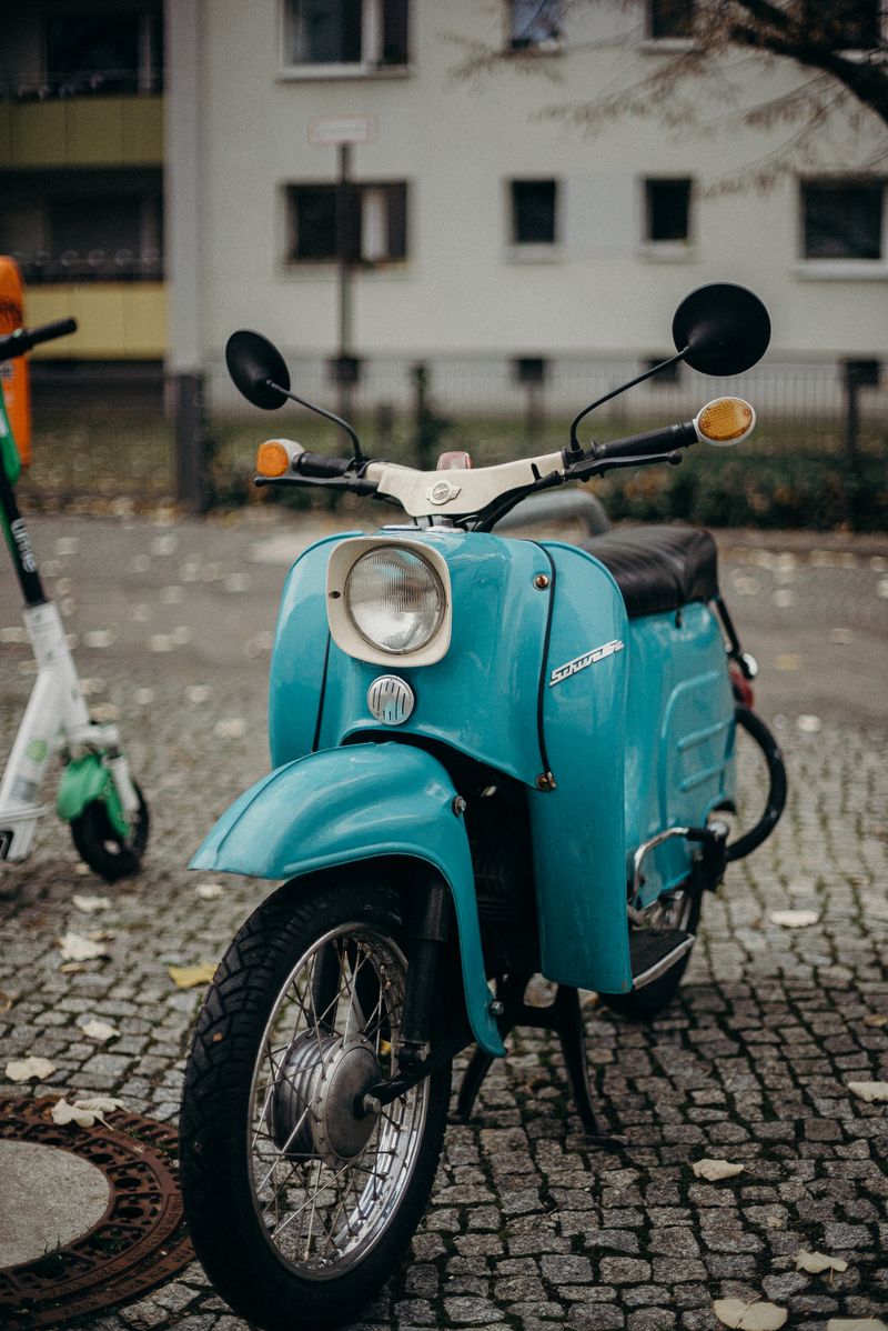 Blauwe klassieke scooter op straatkeien