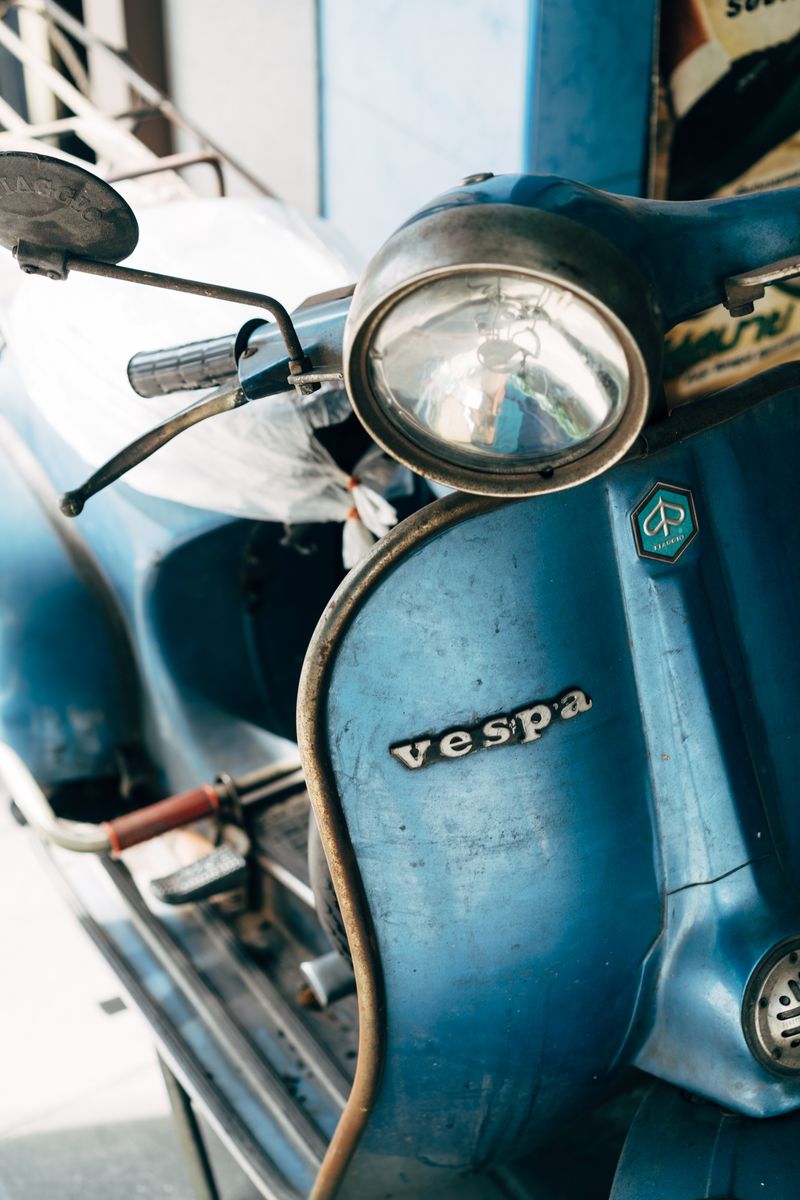 Detail van een verweerde blauwe scooter