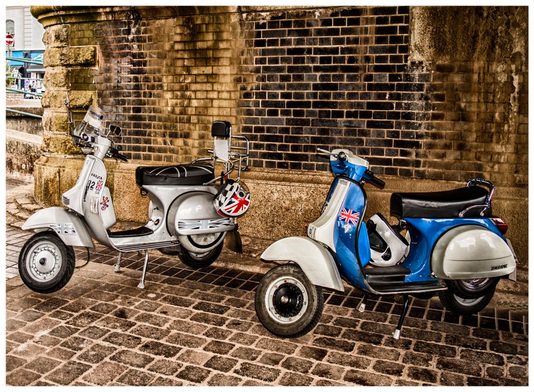 Twee klassieke scooters onder een oude bakstenen boog