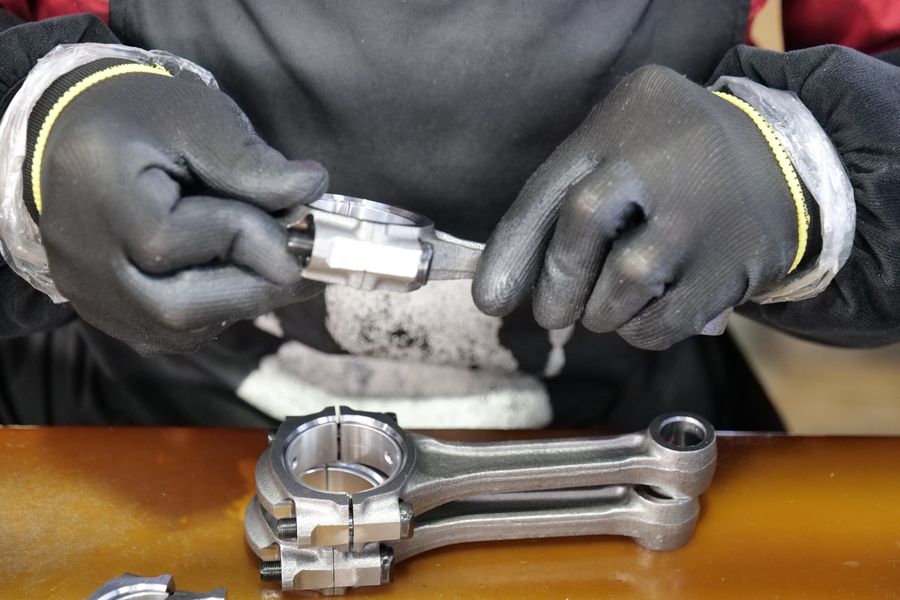 Handen met handschoenen houden een drijfstang vast